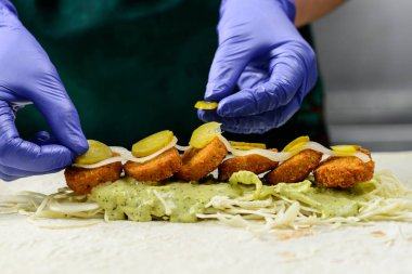 Bilinmeyen Şef lezzetli Falafel rulo, yakın çekim hazırlanıyor. Vegetar