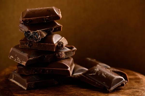 Bar of dark chocolate. Broken pieces of chocolate on wooden boar — Stock Photo, Image