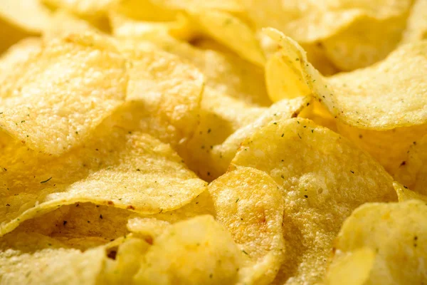 Food background of delicious chips. Corrugated golden chips pota