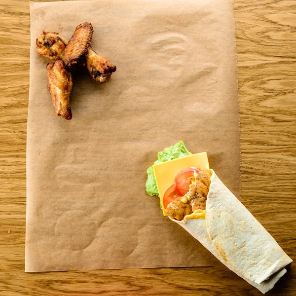 Fast food set: chicken wings and Shawarma on the table with copy