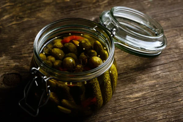 Tarro de vidrio con pepinos caseros en vinagre frescos y bajos en sal en la oscuridad — Foto de Stock