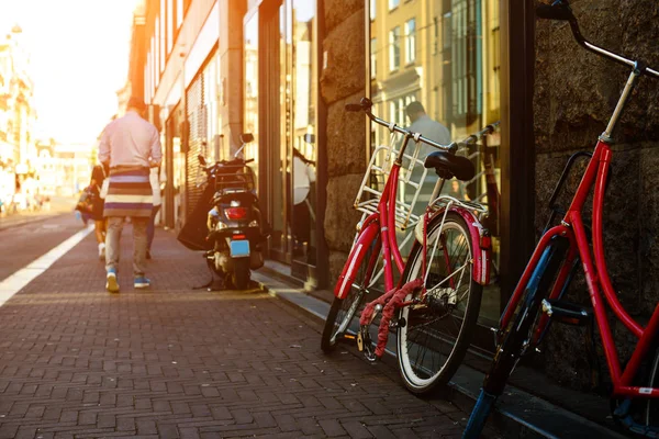 Fahrräder, die auf der stadtstraße in amsterdam in den strahlen der s — Stockfoto