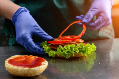 Bilinmeyen cook vejetaryen burger koyarak hazırlamak dilimlenmiş domates üzerinde 