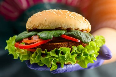 Kimliği belirsiz Şef lezzetli sulu burger içinde ışınları tutarak 