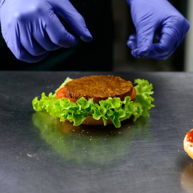 Kimliği belirsiz Şef Veggie burger lezzetli sebze p ile hazırlama
