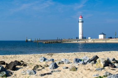 Bir deniz güneşli günde bulunan beyaz deniz feneri. İçinde sembolü