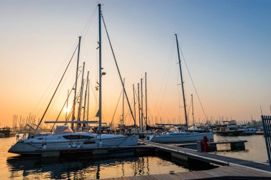 Modern teknelerden ve güneşler, liman içinde park edilmiş lüks yatlar