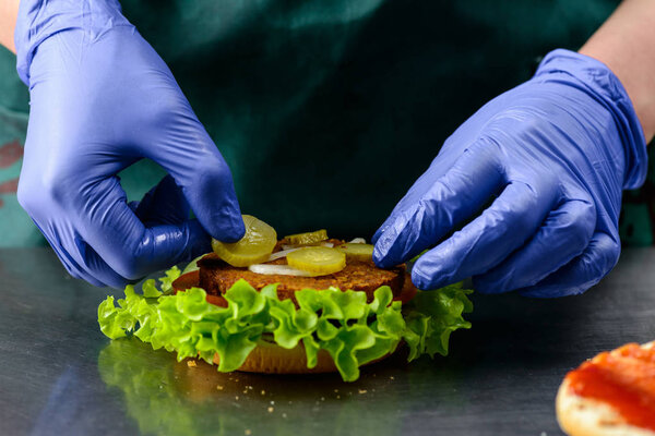 Unidentified chef preparing delicious juicy burger