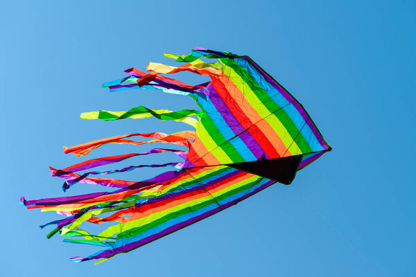 Colorful bright kite in the blue sky on summer day