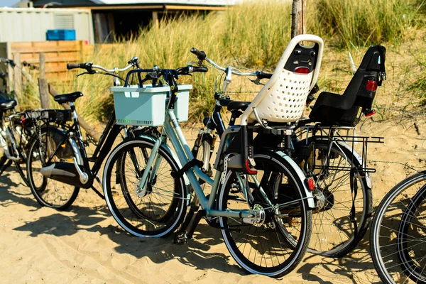 Zaparkowane rowery z koszem na piaszczystej plaży — Zdjęcie stockowe