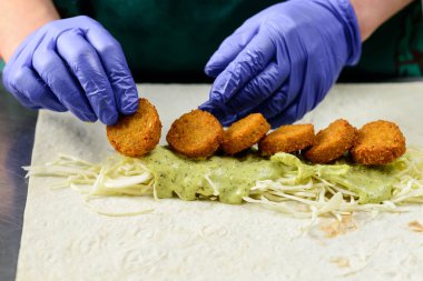 Bilinmeyen Şef lezzetli Falafel rulo, yakın çekim hazırlanıyor. Vegetar