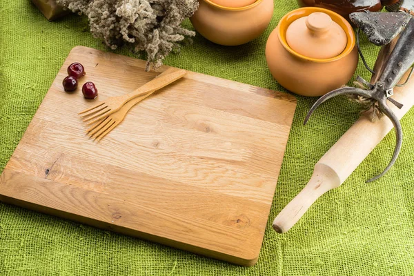 Still life with clay food pot cherries on the wooden board with — Stock Photo, Image