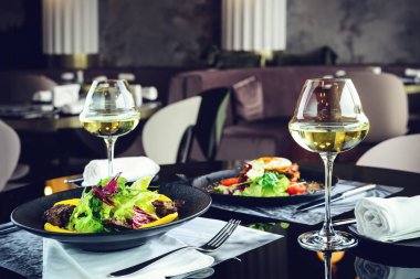 Bir restoranda romantik bir akşam yemeği. İştah açıcı yemekler etli ve