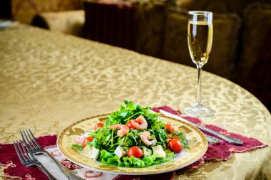 Salata karides, marul yaprakları ve domates ile bir tabak içinde 