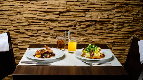 Cena romántica en un restaurante. Platos apetitosos sobre la mesa . — Foto de Stock