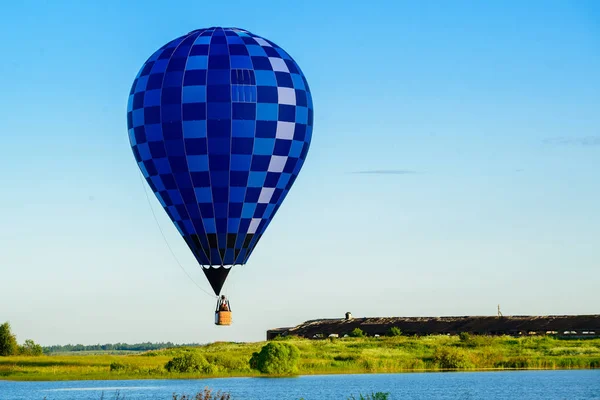 Gölde açık bl üzerinde uçan parlak renkli sıcak hava balonu — Stok fotoğraf