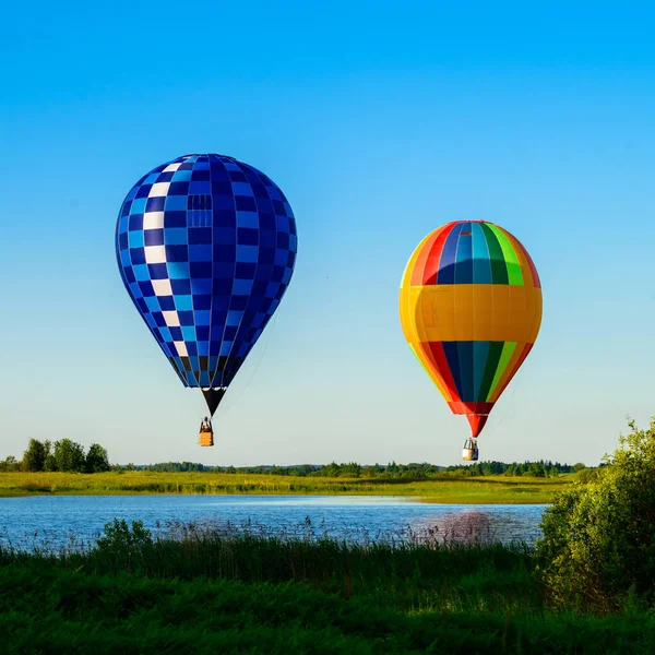 Belli B'deki göl üzerinde uçan parlak renkli sıcak hava balonları — Stok fotoğraf