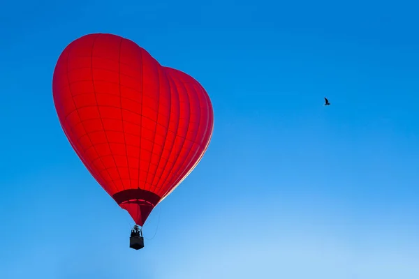 Knallroter Heißluftballon in Herzform gegen blaues Licht — Stockfoto