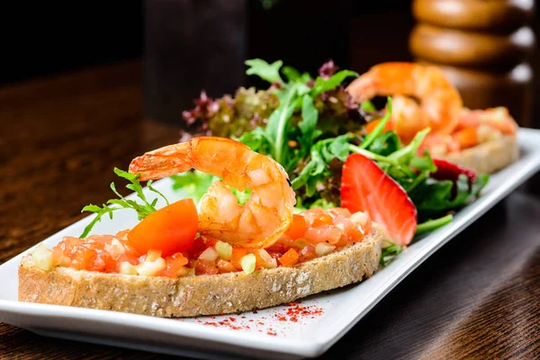 Delicioso plato de mariscos. Pan con tomates y gambas y basi —  Fotos de Stock