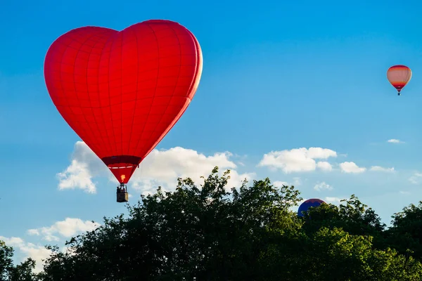 明亮的红色热气球在心脏的形状反对蓝色 sk — 图库照片