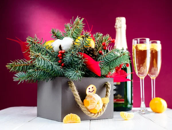 Очки с шампанским и рождественские украшения коробки против розового — стоковое фото