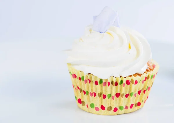 Appetizing sweet dessert. White glaze cupcake with cream on ligh — Stock Photo, Image