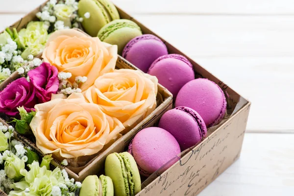 Geschenkbox mit Blumen und Makronen — Stockfoto