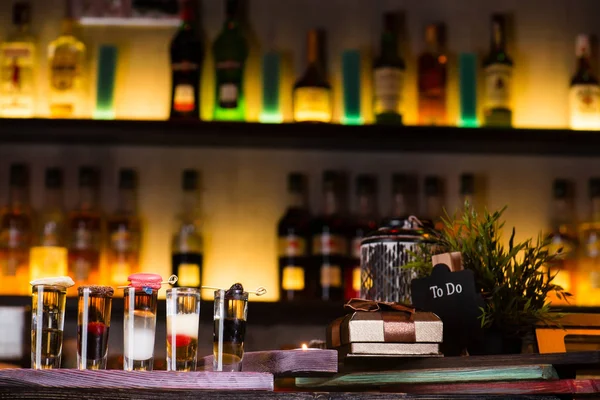 Conjunto de coloridos cócteles alcohólicos en vasos de chupito en la barra borrosa — Foto de Stock