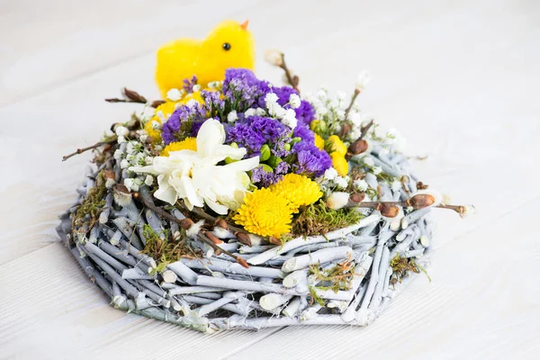 Frohe Ostern, gelbes Küken im Nest, frische Blumen — Stockfoto