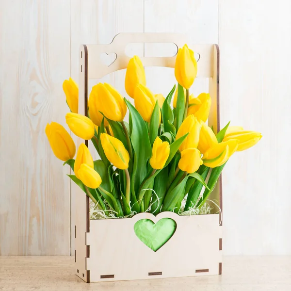 Yellow tulips in a wooden pot — Stock Photo, Image