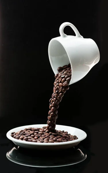 ソーサーにカップからコーヒー豆が注がれる — ストック写真