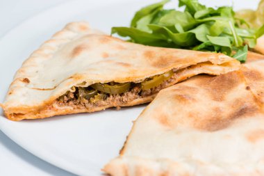 Bir plaka üzerinde baharatlı kapalı pizza yiyelim