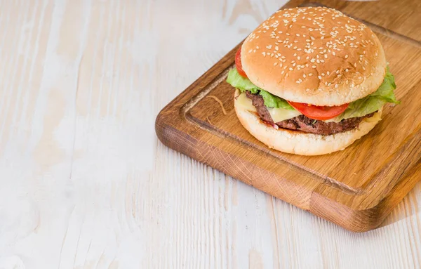 Leckerer Burger auf hölzernem Hintergrund — Stockfoto