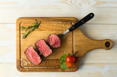 bir kesme tahtası üzerinde biftek dilimlenmiş
