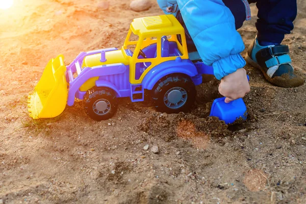 Um menino brincando com um trator de brinquedo — Fotografia de Stock