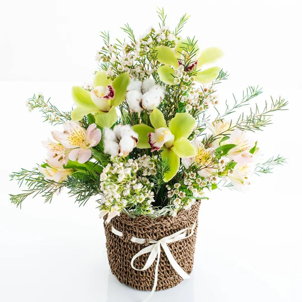 a bouquet of orchid flowers in a wicker basket