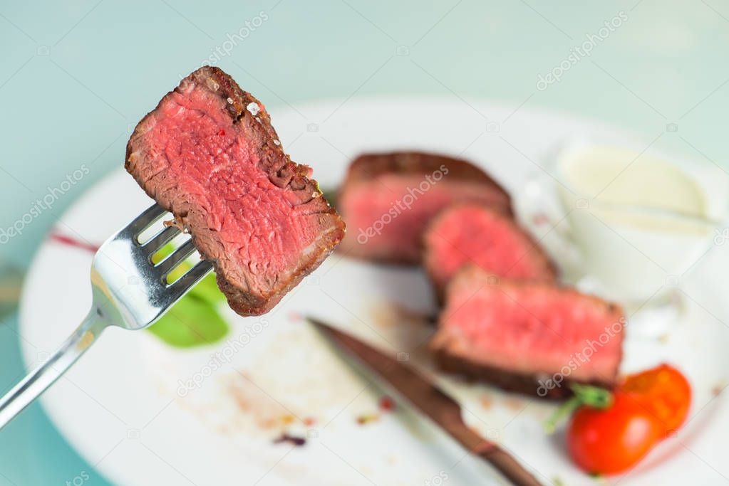 beef steak impaled on fork