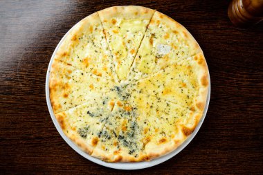 İştah açıcı sıcak dört peynirli Pizza masanın üzerinde. Üstten görünüm, düz la