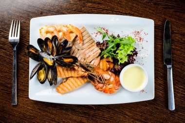 Lezzetli deniz ürünleri tabağı. Balık fileto, mossels ve karides kablosuz servis