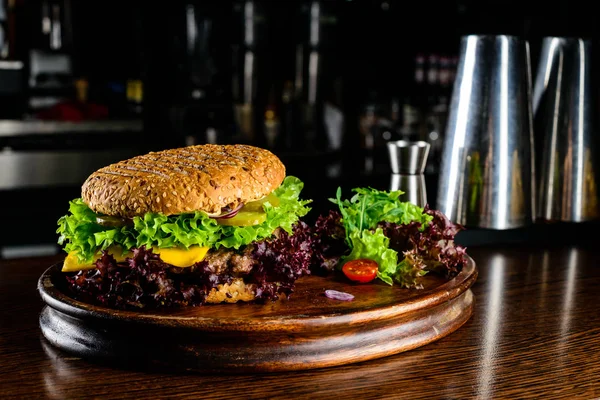 Chutné burger s hovězí steak, sýrem, salátem a cibulí na wo — Stock fotografie