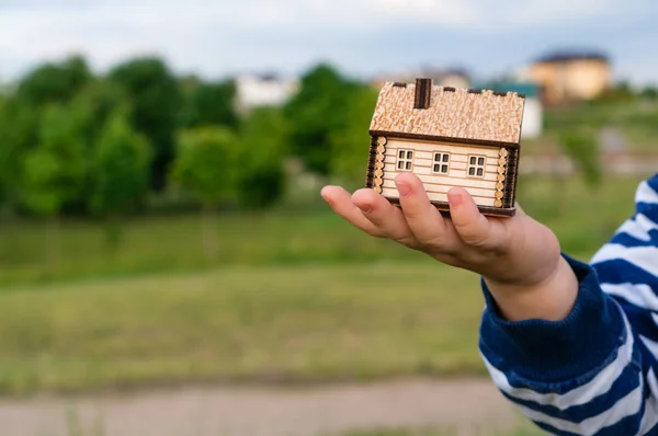 Malý domek v rukou dítěte — Stock fotografie