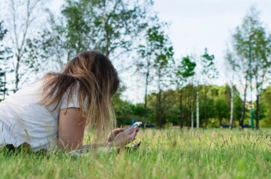 Kız çimlerin üzerinde yatıyor.