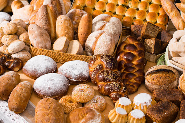 различные виды свежего хлеба в столе: ром баба, халла, пшеница
