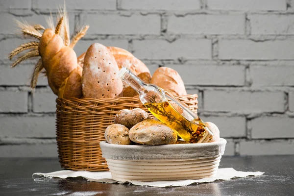 Various types of fresh bread in a basket, a traditional round ar — Stock Photo, Image