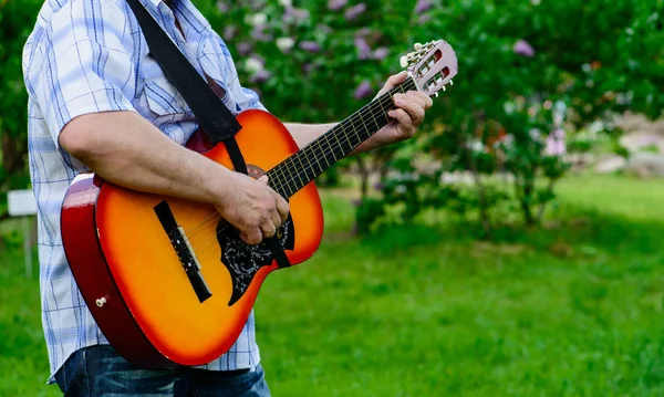 Człowiek z gitarą w rękach — Zdjęcie stockowe