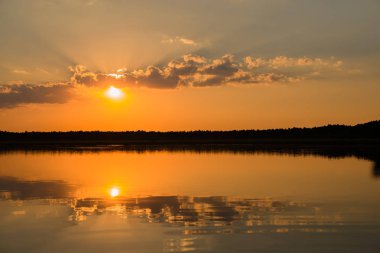 suya yansıyan turuncu günbatımı