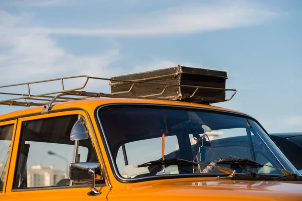 Koffer auf Autodach gegen den blauen Himmel, flach — Stockfoto