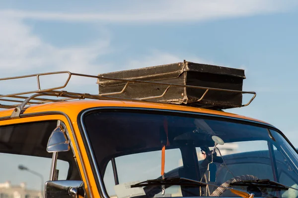 Чемодан на крыше автомобиля багажей против голубого неба — стоковое фото