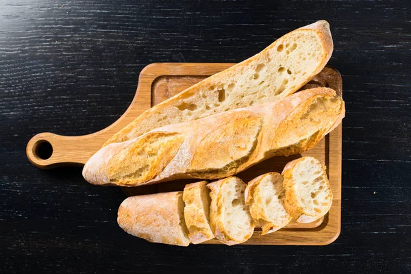 Tranches de baguette de pain frais français avec piscine et sur un bois — Photo