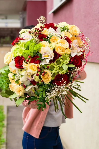 Mujer recibió un hermoso ramo de rosas rojas y beige, chrys —  Fotos de Stock